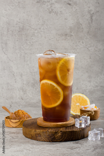 sweet lemonade tea in plastic cup with iced on texture  background, summers refreshment.