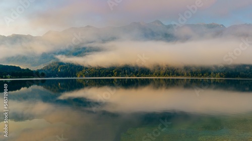 Fototapeta Naklejka Na Ścianę i Meble -  Aerial view of Bohinj lake surrounded by dense trees in morning
