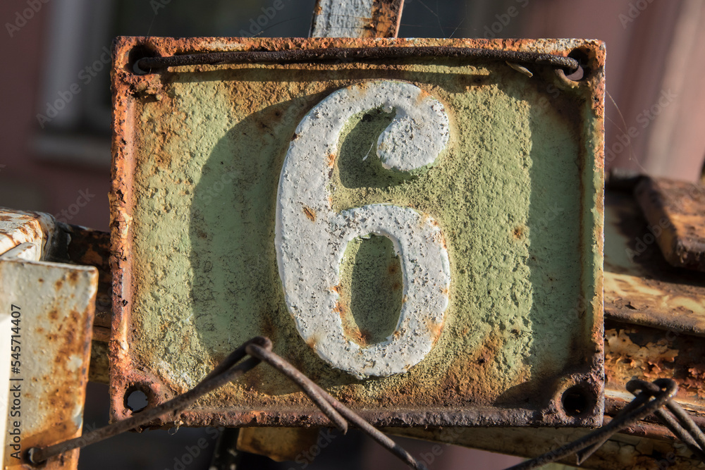 Old retro weathered cast iron plate with number 6 