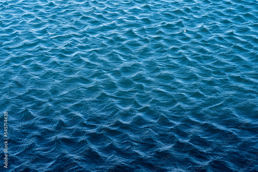Obraz premium Blue sea surface with waves and ripples