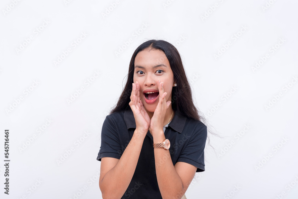 A young woman announcing an important message by yelling. Covering her mouth with her hands. Isolated on a white backdrop. A young woman announcing an important message by yelling. Covering her mouth with her hands. Isolated on a white backdrop.