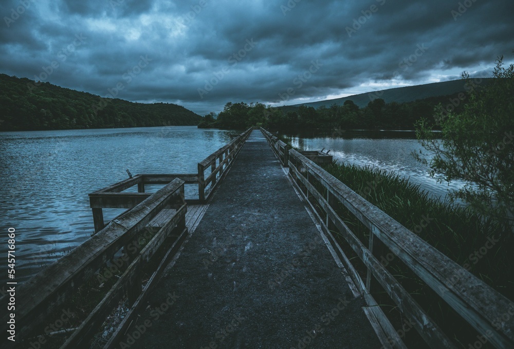 Fototapeta premium Empty bridge against the background of the cloudy sky.