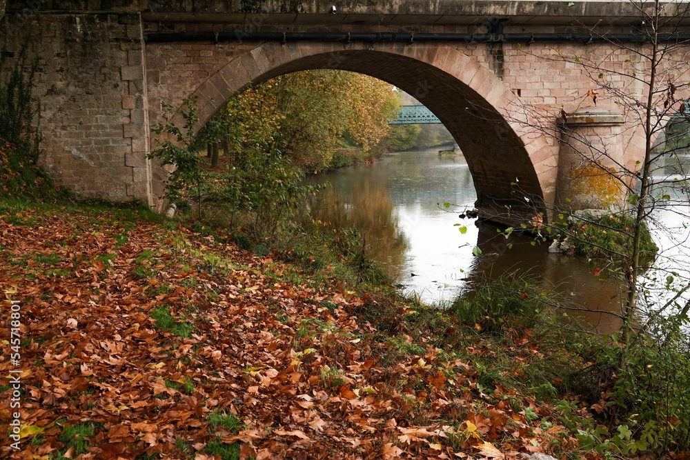 Beautiful shot of a bridge reflecting on a river surface during autumn