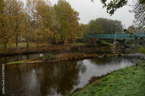 Scenic view of a bridge over a river during autumn on a cloudy day