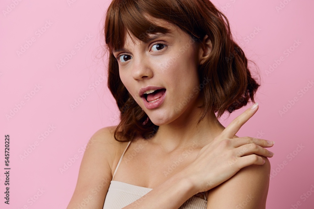 a close horizontal photo of a happy, attractive young woman on a pink background, smiling happily and gently holding her hand in a relaxed movement near the shoulder a close horizontal photo of a happy, attractive young woman on a pink background, smiling happily and gently holding her hand in a relaxed movement near the shoulder
