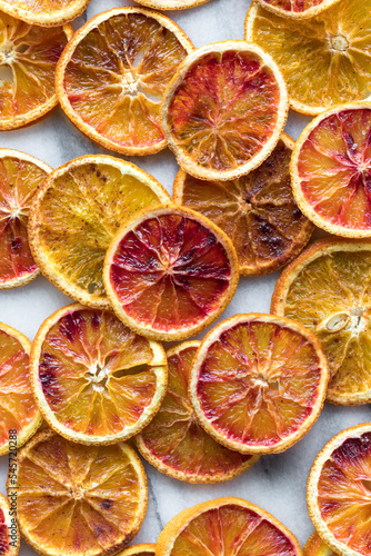 Top down view of several dried spiced orange slices against a light background.