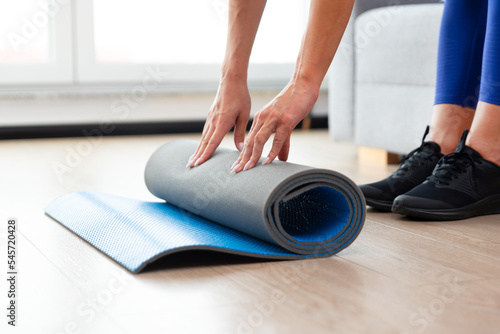 Woman folding mat, workout at home concept
