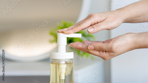 Woman with bottle of soap in bathroom