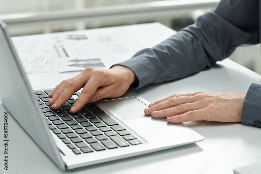 Close-up of young secretary typing on computer keyboard while working at table at office Close-up of young secretary typing on computer keyboard while working at table at office