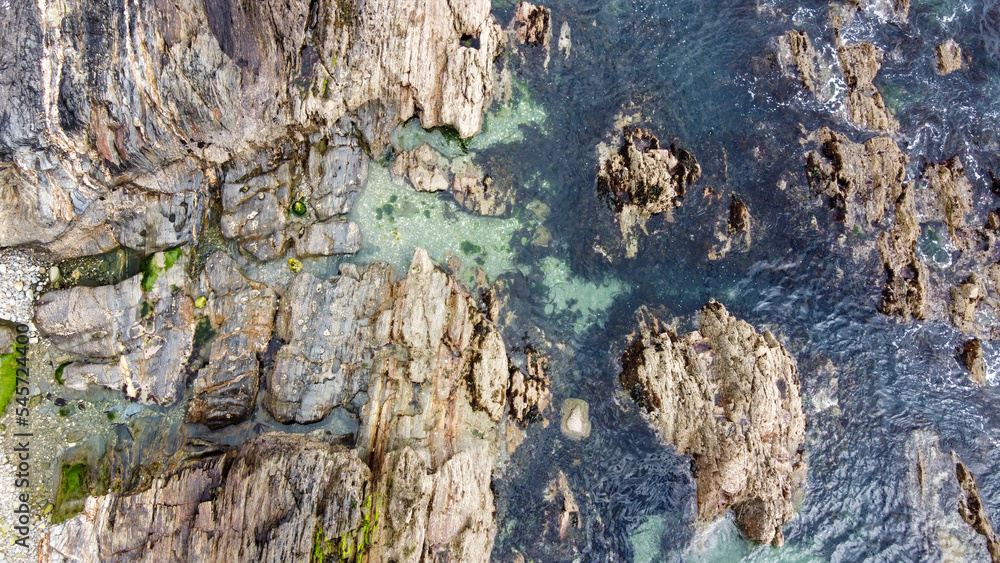 Drone photo. View from above. A lot of boulders in the sea water, top view. Coastal cliffs of the North Atlantic. Seaside beautiful nature. Dramatic seascape of the north of Europe. Drone photo. View from above. A lot of boulders in the sea water, top view. Coastal cliffs of the North Atlantic. Seaside beautiful nature. Dramatic seascape of the north of Europe.