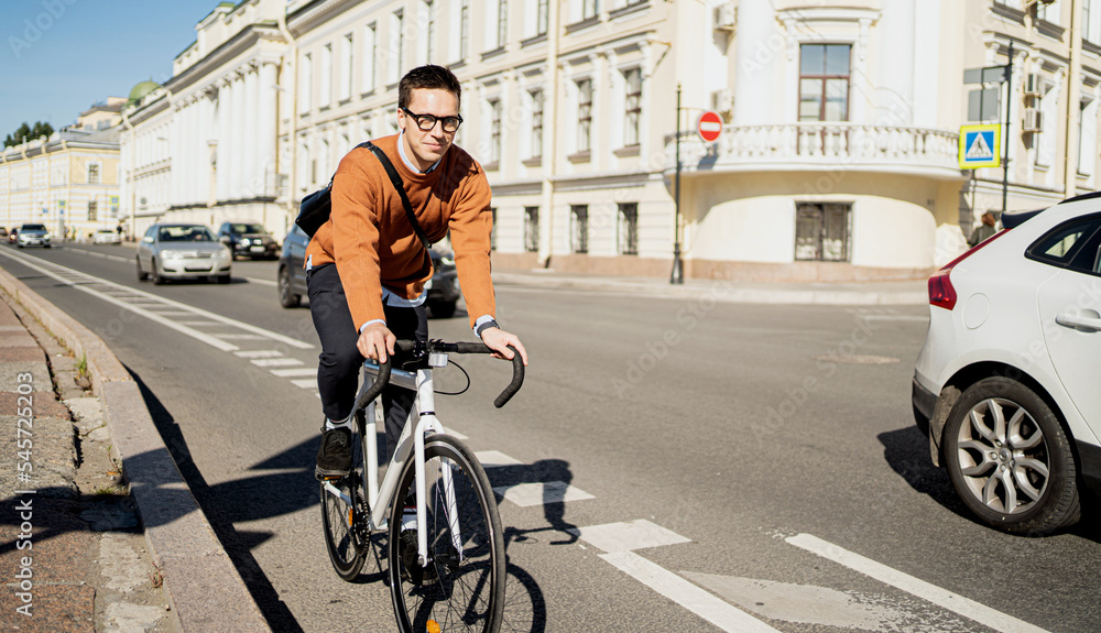 A male cyclist rides a bicycle to work in the city. Ecological transport is modern.