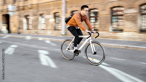 Blurry photo Photography in motion. A bicyclist rides a bicycle to work in the city. Ecological transport is modern.