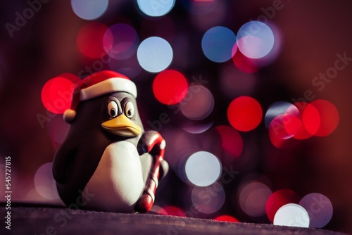 Closeup of a penguin toy with Santa Claus hat on bokeh background