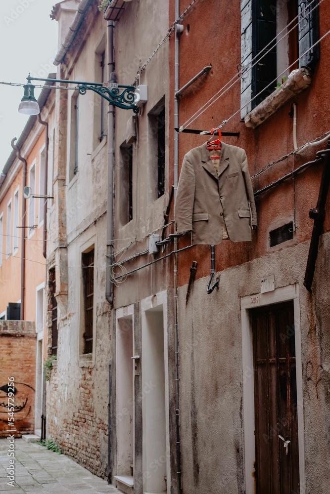 Fototapeta premium Vertical shot of a residential building with a hung suit in Venice, Italy