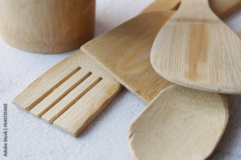  wooden cutlery fork and spoon on a chopping board on table 