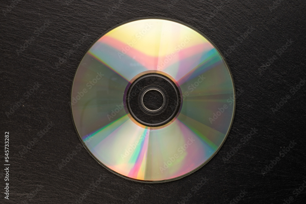 One CD-R disc on slate stone, macro, top view.