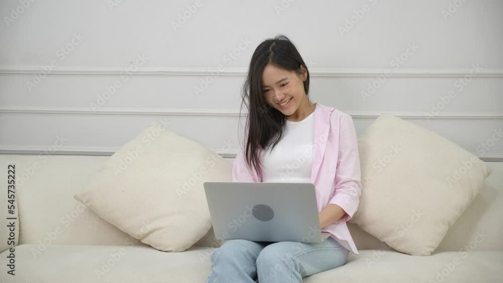 Young asian business woman work from home with laptop computer online to internet on sofa in living room, freelance girl using notebook sitting on couch with comfort and relax, lifestyles concept. Young asian business woman work from home with laptop computer online to internet on sofa in living room, freelance girl using notebook sitting on couch with comfort and relax, lifestyles concept.