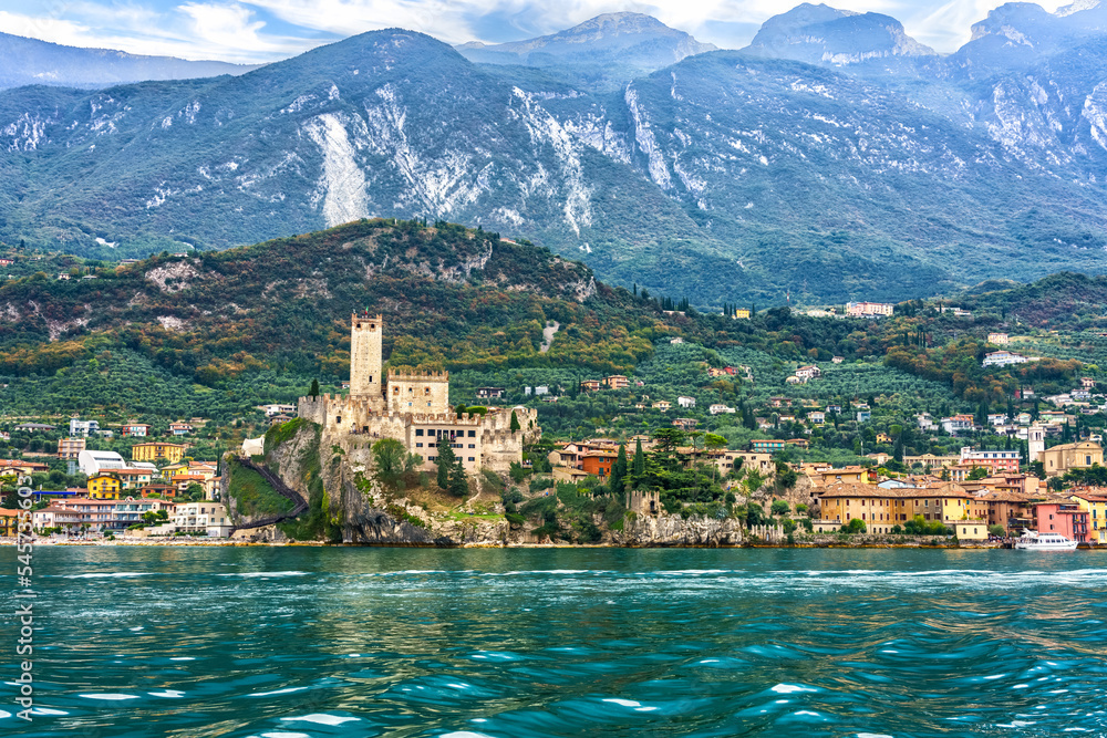 View to old town Malcesine with ancient tower and fortress at Garda lake, Veneto region, Italy, mountains in the background. 