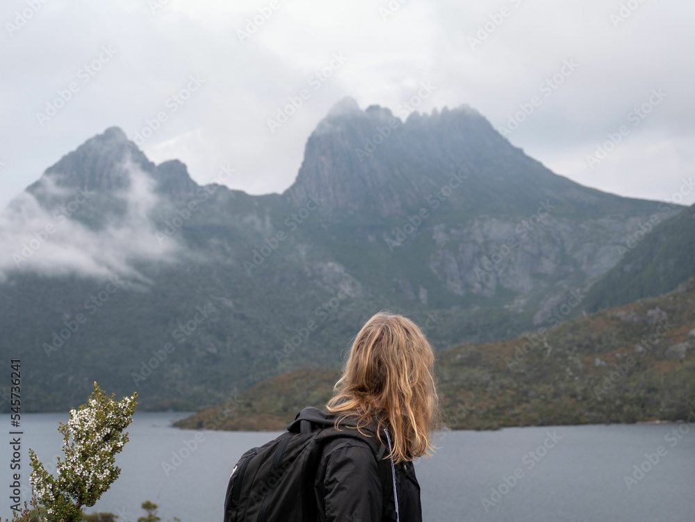Young Australian woman traveling through the woods with rocky mountains in the background