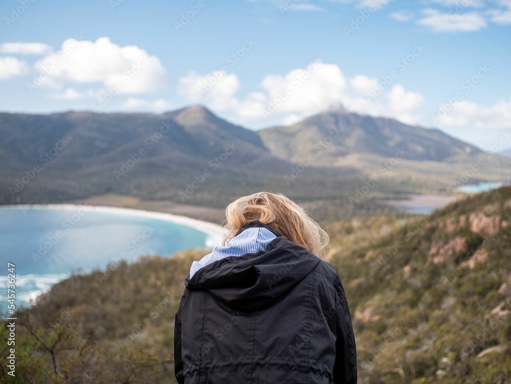 Young Australian woman traveling through the woods with rocky mountains in the background