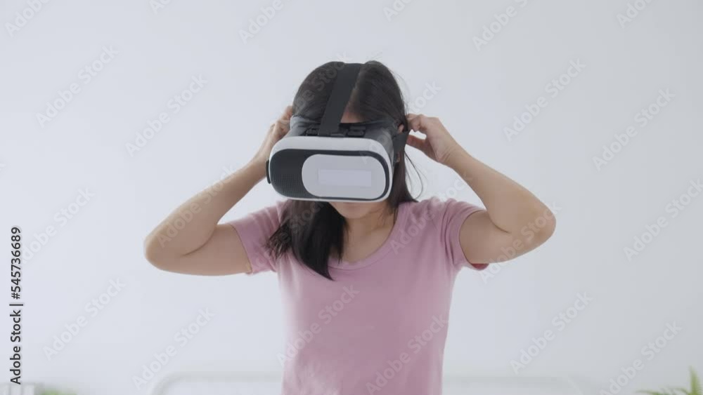 Young asian woman wearing vr headset playing game with excited on bed in the bedroom at home, female using virtual reality or metaverse innovation for simulation 3D, lifestyles and technology concept. Young asian woman wearing vr headset playing game with excited on bed in the bedroom at home, female using virtual reality or metaverse innovation for simulation 3D, lifestyles and technology concept.