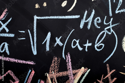 mathematical formulas written in chalk on a slate wall
