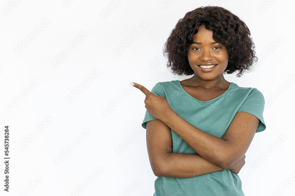 Attractive young woman pointing at left upper corner. Happy African ...