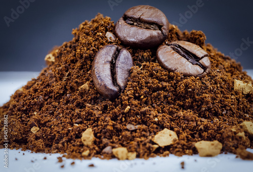 close up of coffee beans in a pile of ground coffee powder