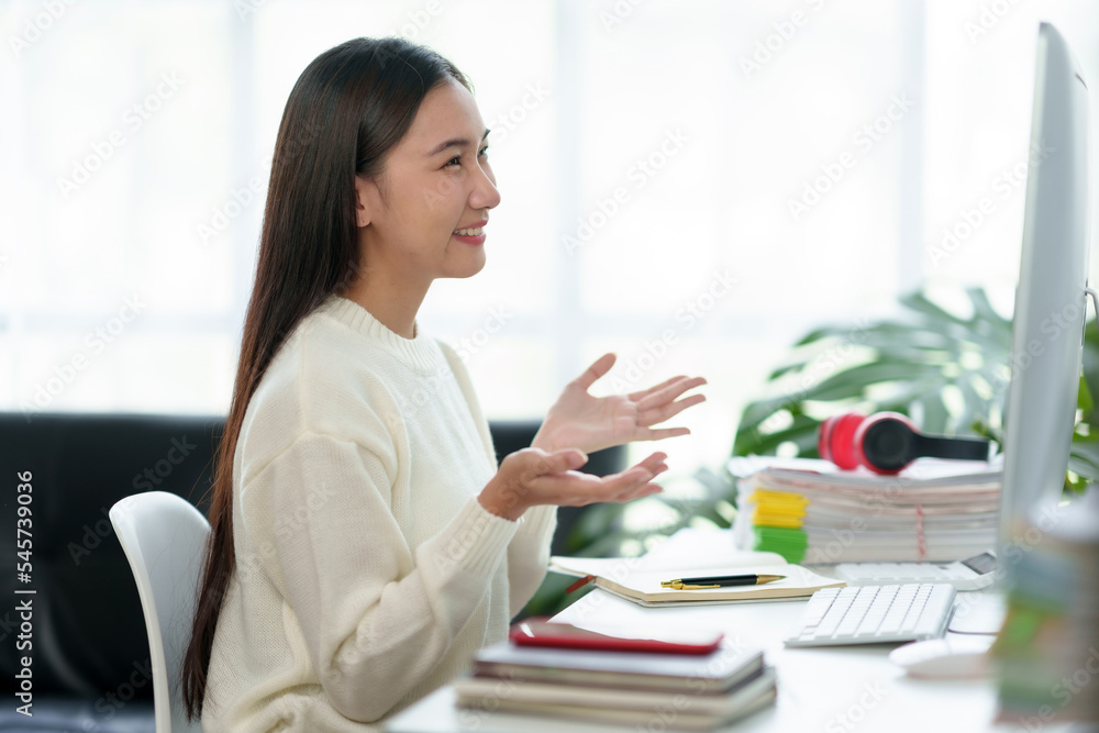 Beautiful young Asian business woman sit on a laptop video conference to discuss work and ongoing business.