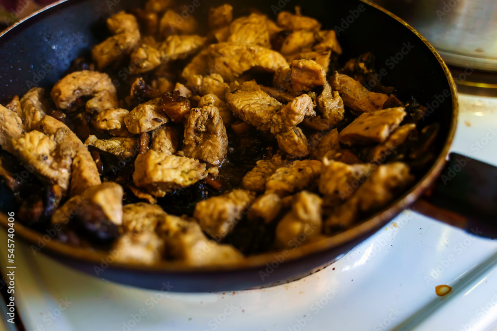 Meat with mushrooms is fried in a frying pan in oil Meat with mushrooms is fried in a frying pan in oil
