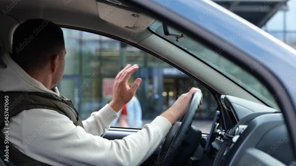 Male sitting in car waiting for daughter looking in window. Rear of male sit in vehicle waits for his kid from school. Man pick up his daughter. Teenage girl running crossing the street Male sitting in car waiting for daughter looking in window. Rear of male sit in vehicle waits for his kid from school. Man pick up his daughter. Teenage girl running crossing the street
