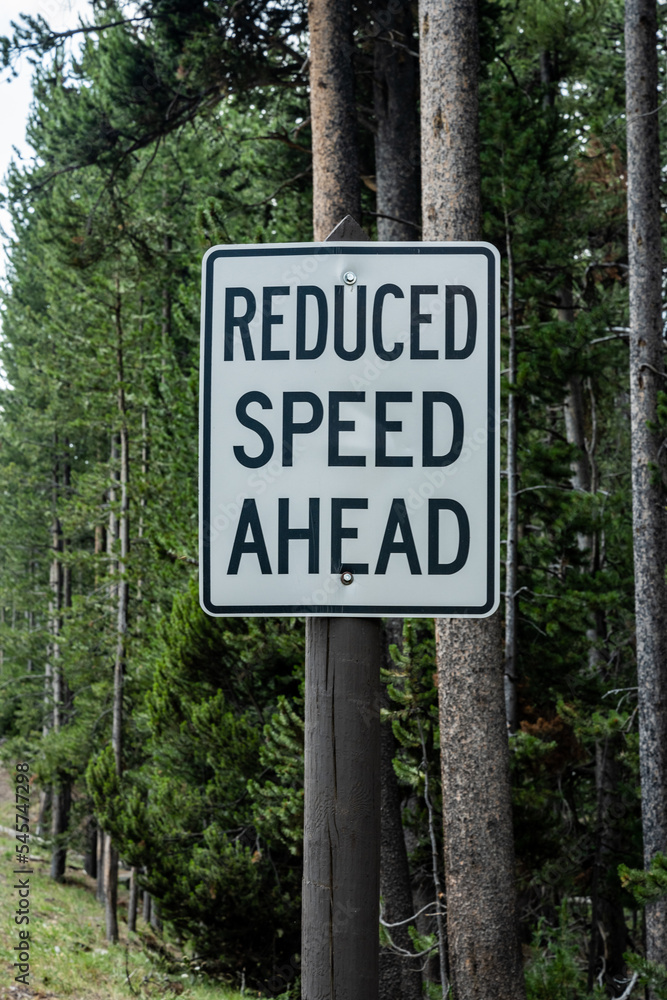 Reduced Speed Ahead Sign on Wooden Post