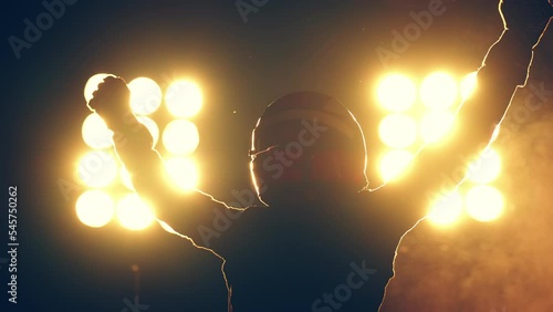 Silhouette of race car driver celebrating the win in a race against bright stadium lights. 100 FPS slow motion shot photo