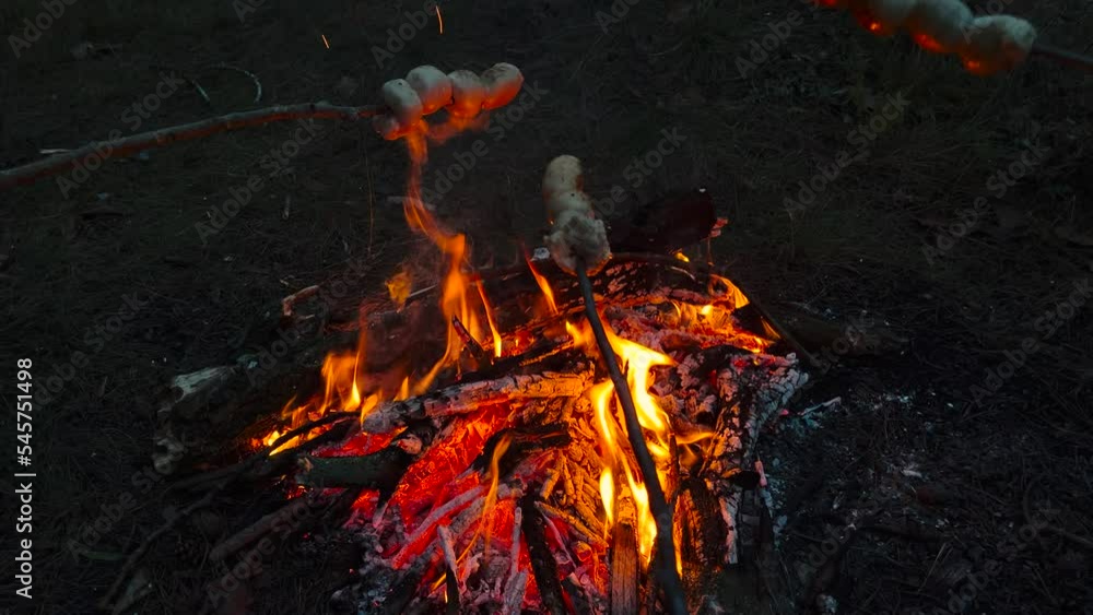 Cooking Camping Meals On the Fire. Roasting Hot Dog on Campfire. Sausages Impaled on Skewers are Fried on a Fire. Fire Burning Bright At The Center Of The Camp. Bonfire, Smoke, Spike, Camping Cooking Camping Meals On the Fire. Roasting Hot Dog on Campfire. Sausages Impaled on Skewers are Fried on a Fire. Fire Burning Bright At The Center Of The Camp. Bonfire, Smoke, Spike, Camping