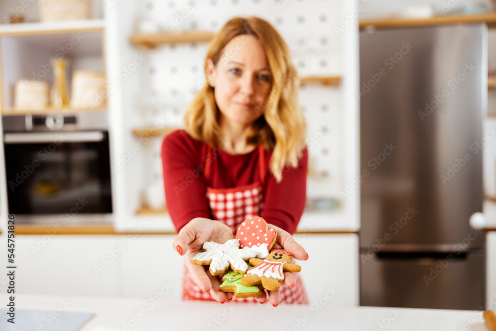 Selective focus on woman's hands holding christmas ginger cookies.