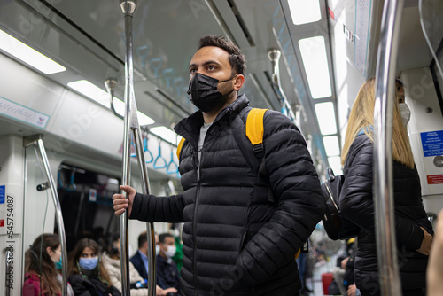A passenger travelling with Turkish metro. He wears black medical mask.