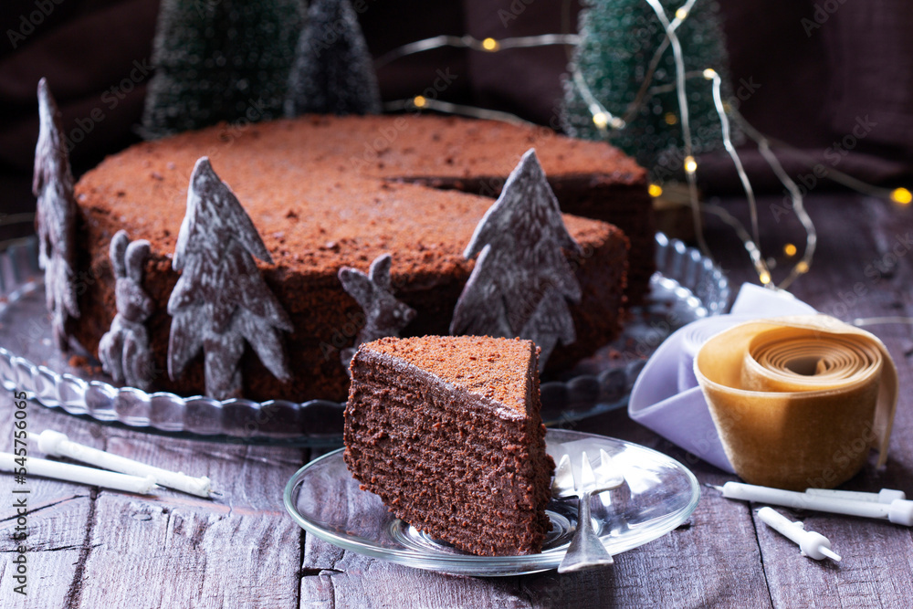 Chocolate honey cake in a Christmas decoration on a wooden background.