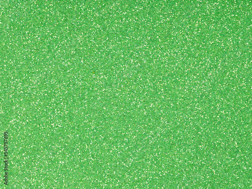 Festive soft green holographic glitter. Bright glowing green background for St.Patrick's Day, Christmas, New Year, xmas gift card or other holiday pictures. Beautiful packaging material.