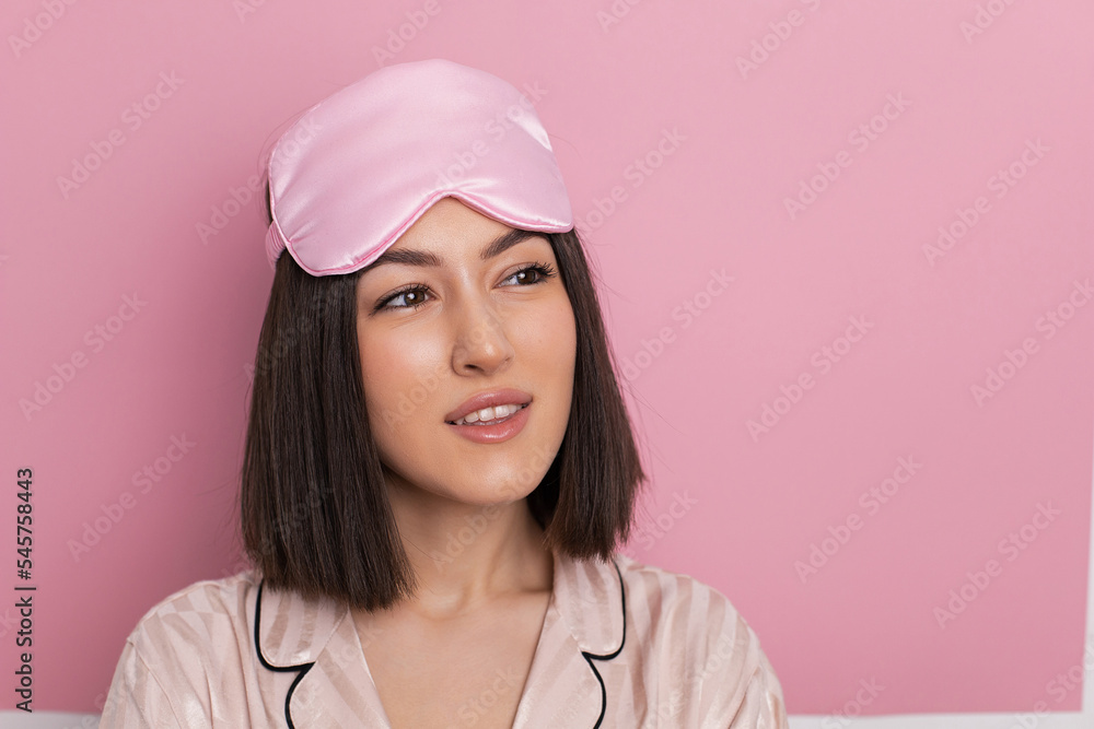 Porter is a beautiful young woman of oriental appearance standing in pink pajamas and a sleeping mask in the bedroom. suffers from insomnia. Porter is a beautiful young woman of oriental appearance standing in pink pajamas and a sleeping mask in the bedroom. suffers from insomnia.