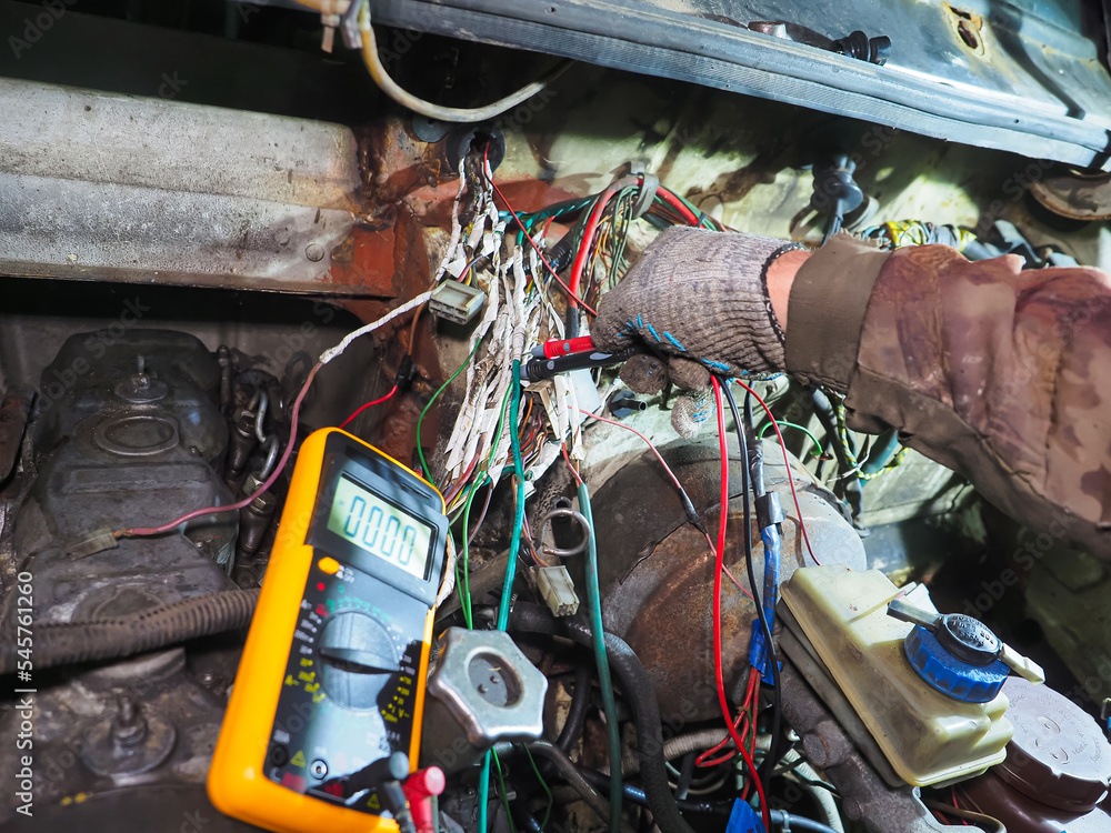 electrician checks the wiring of the car with a device Stock Photo