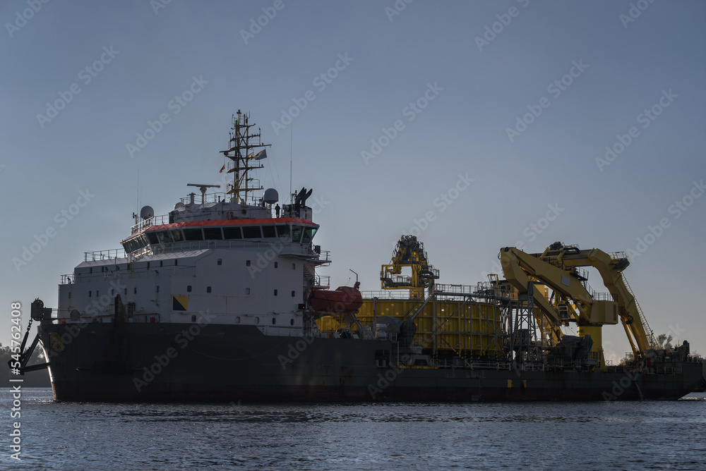 Fototapeta premium MARITIME ENGINEERING - Cable laying vessel is sailing along the port channel to sea