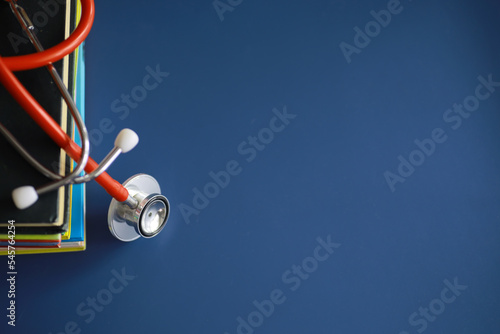 stethoscope on stack of medical guide book for doctor learning treatment at hospital.