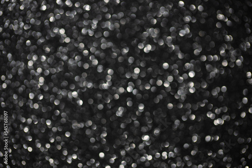 Dark silver sparkling bokeh background. Christmas or holiday glitter texture.