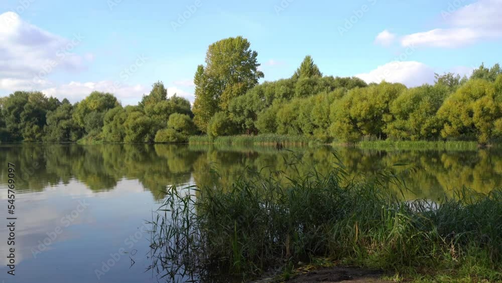 Green park next to the reservoir near the city in early autumn. Panorama along the horizon line. Green park next to the reservoir near the city in early autumn. Panorama along the horizon line.