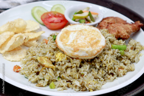 delicious Indonesian Food, Fried rice chicken and eggs with slice cucumber and tomato for garnish