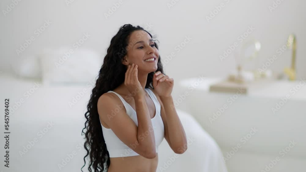 Natural beauty. Young pretty curly woman looking at mirror and smiling, enjoying her attractive appearance, free space Natural beauty. Young pretty curly woman looking at mirror and smiling, enjoying her attractive appearance, free space