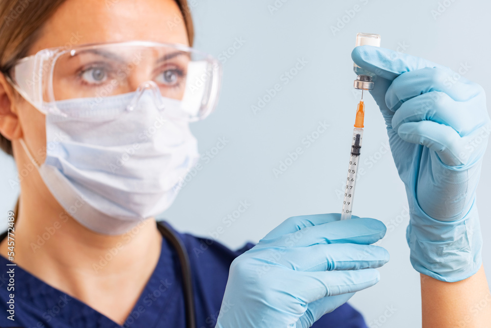 Doctor in surgical mask and gloves preparing syringe for injection Doctor in surgical mask and gloves preparing syringe for injection
