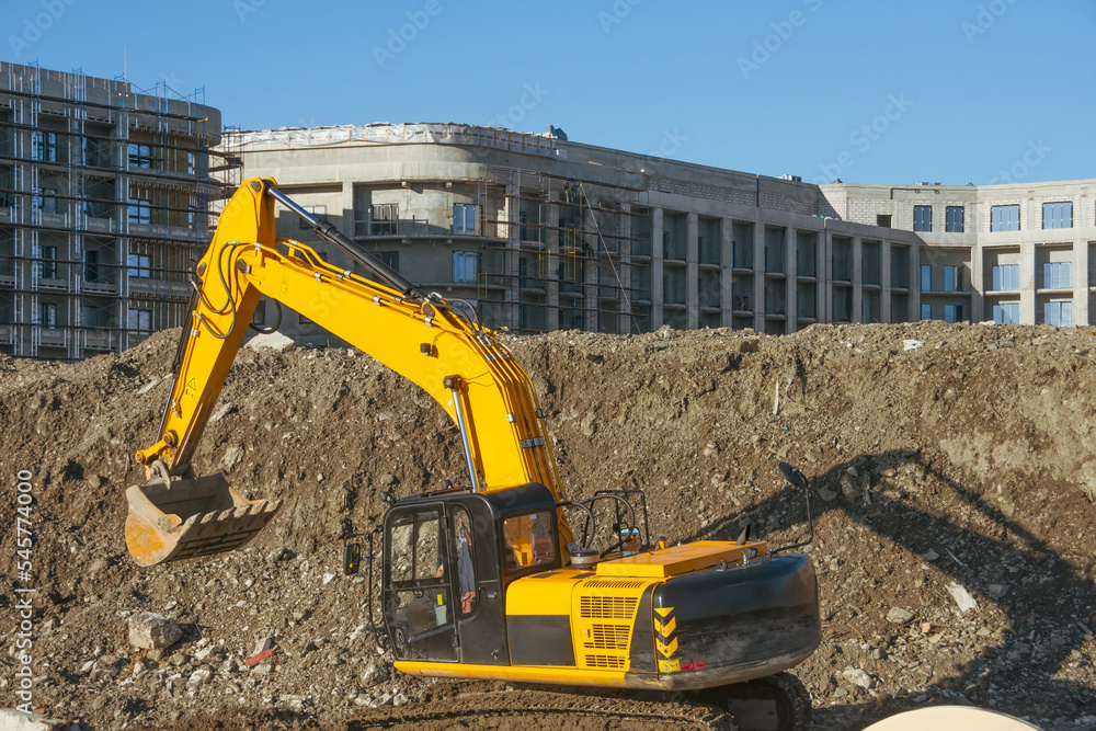 Excavator on earthworks at construction site. Backhoe on foundation work and road construction. Heavy machinery and construction equipment. Excavator on earthworks at construction site. Backhoe on foundation work and road construction. Heavy machinery and construction equipment.