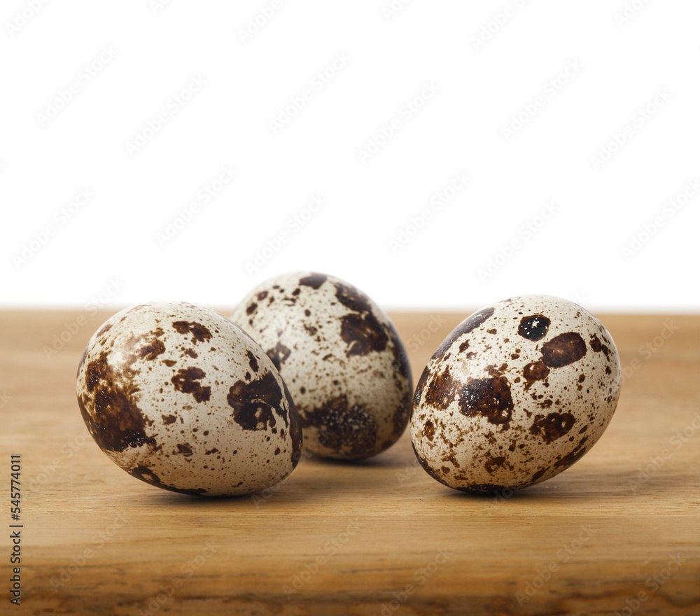 Obraz premium Quail eggs on a wooden table isolated on a white background.