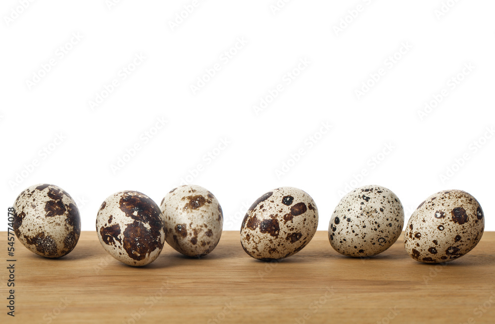 Quail eggs on a wooden table isolated on a white background. Quail eggs on a wooden table isolated on a white background.